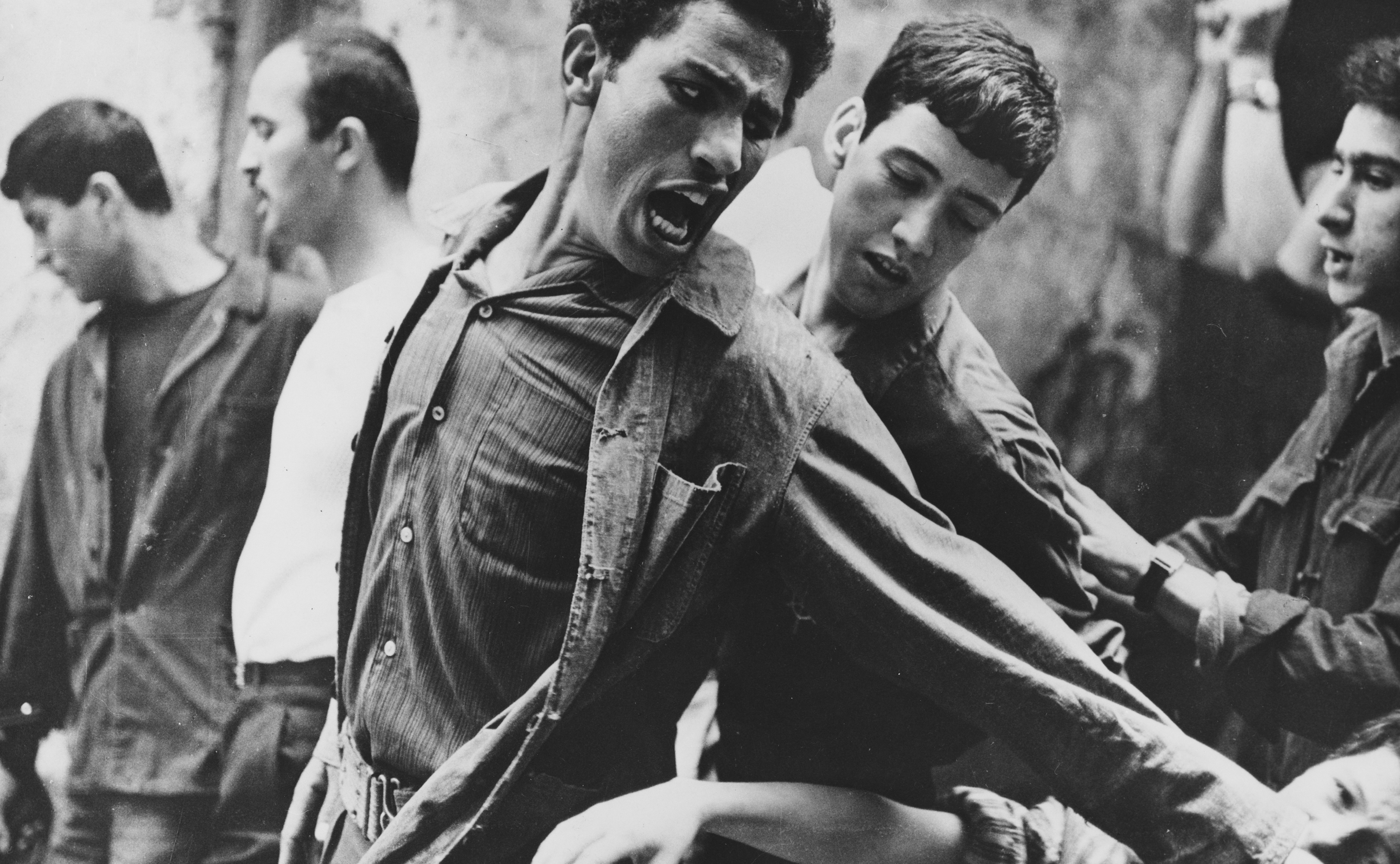 Brahim Haggiag (center, with arm outstretched) as  revolutionary